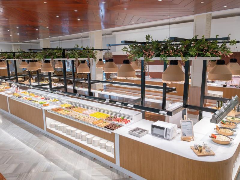 Elegant buffet area with a variety of dishes and light wooden furniture in a modern setting.