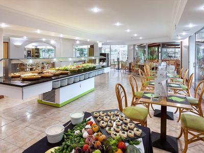 Bright dining room with buffet and tables by the window with wooden chairs