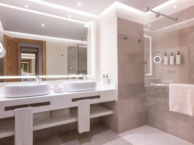 Moderne badkamer met grote verlichte spiegelwand en dubbele wastafels