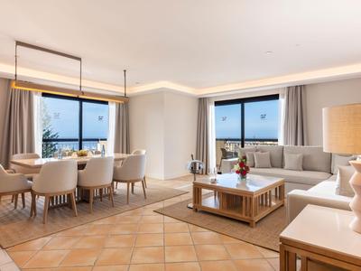 Espace salon et salle à manger lumineux et moderne avec de grandes fenêtres et un mobilier confortable.