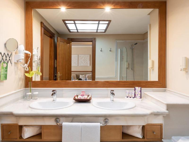 Double lavabo en marbre avec grand miroir dans une salle de bain d'hôtel.