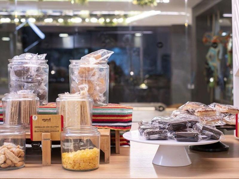 Display of assorted cookies and sweets in clear bags on counter near glass window