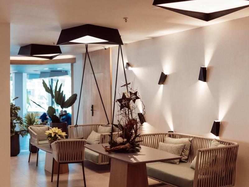 Modern hotel lobby with comfortable seating, plants, and elegant lighting.