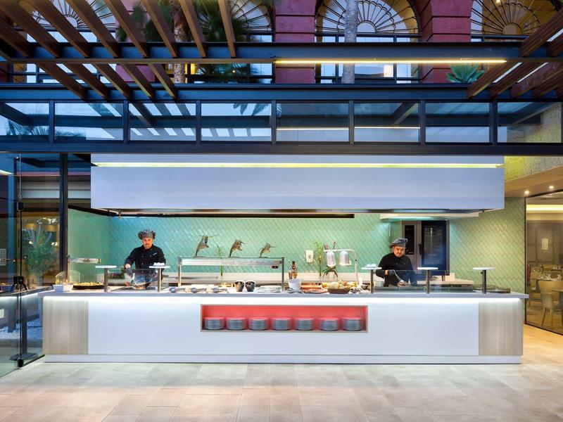 Cucina dell'hotel dal design moderno con area cottura aperta e due chef.