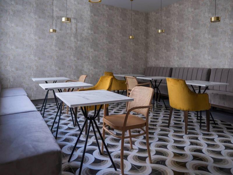 Moderne zithoek met tafels, stoelen en bank in een hotel of restaurant.
