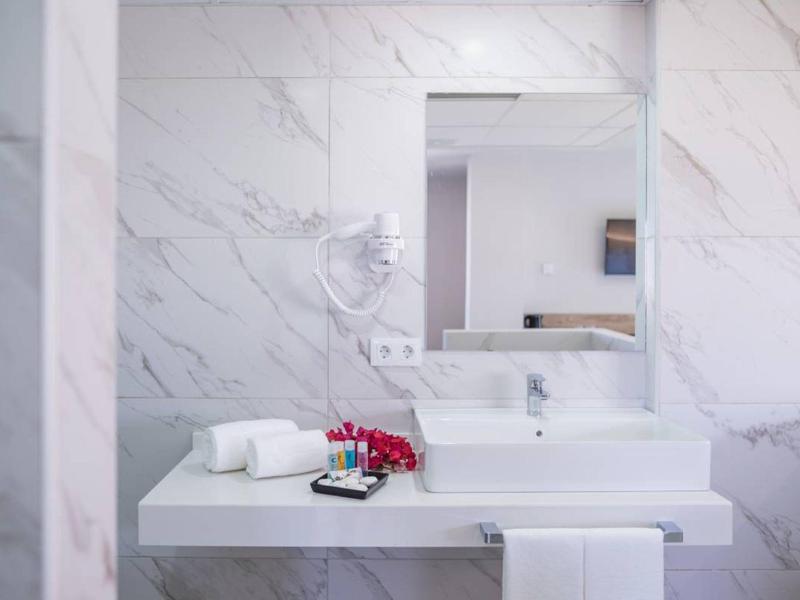 Modern wit badkamer met wastafel, grote spiegel en föhn aan de muur