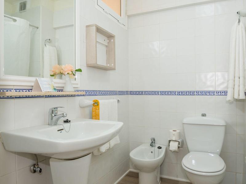 Czysta łazienka z umywalką, bidetem i toaletą w jasnym otoczeniu.