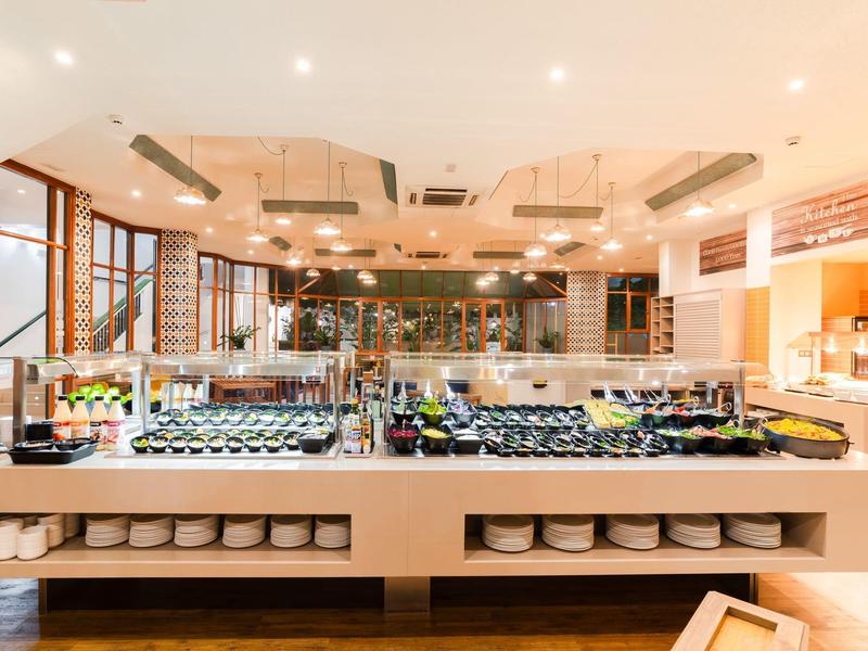 Jasne bufet restauracyjny z różnorodnymi potrawami i otwartymi drewnianymi oknami.