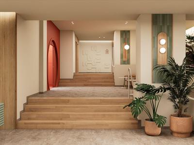 Moderní lobby hotelu s dřevěným schodištěm, rostlinami a teplým osvětlením.