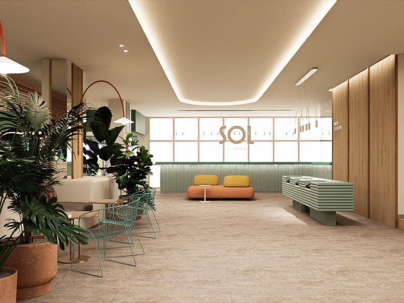 Moderner Hotel-Loungebereich mit Pflanzen, Holzverkleidungen und gemütlichen Sitzgelegenheiten.