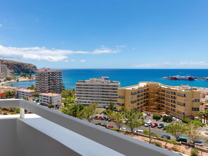 Blick vom Balkon auf Hotels und das Meer bei klarem Himmel.