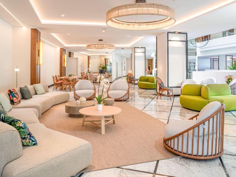 Espace salon d'hôtel lumineux avec mobilier moderne et éclairage élégant.