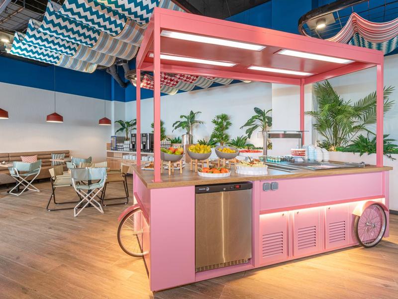 Chariot alimentaire rose clair dans un intérieur moderne avec espace salon et plantes