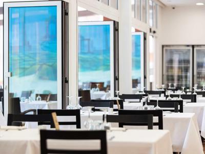 Restaurant lumineux avec des tables blanches et une ambiance détendue.