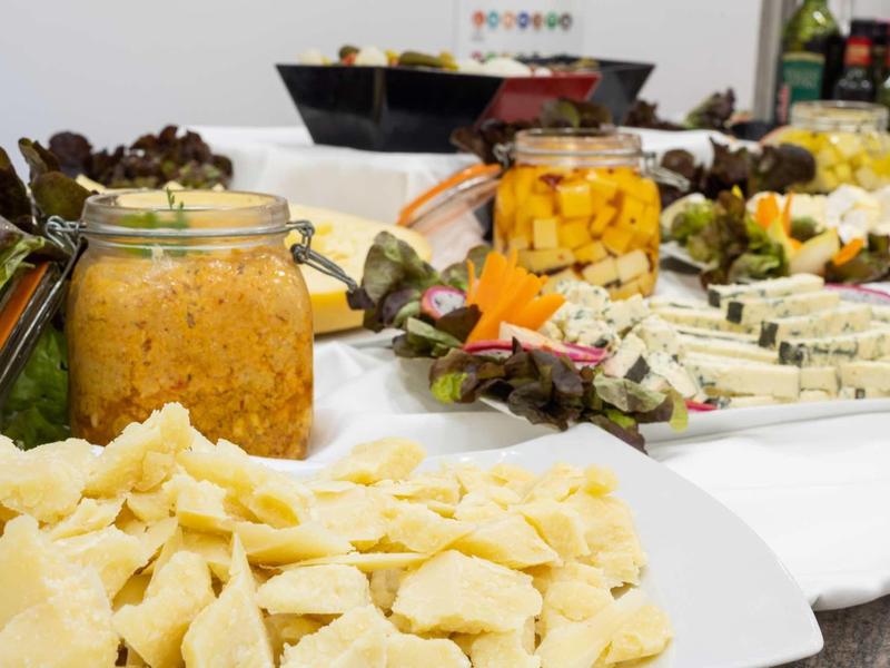 Buffet avec différentes variétés de fromages, fruits secs et noix disposés.