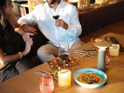 Coppia che mangia e beve a un tavolo di legno in un ristorante.