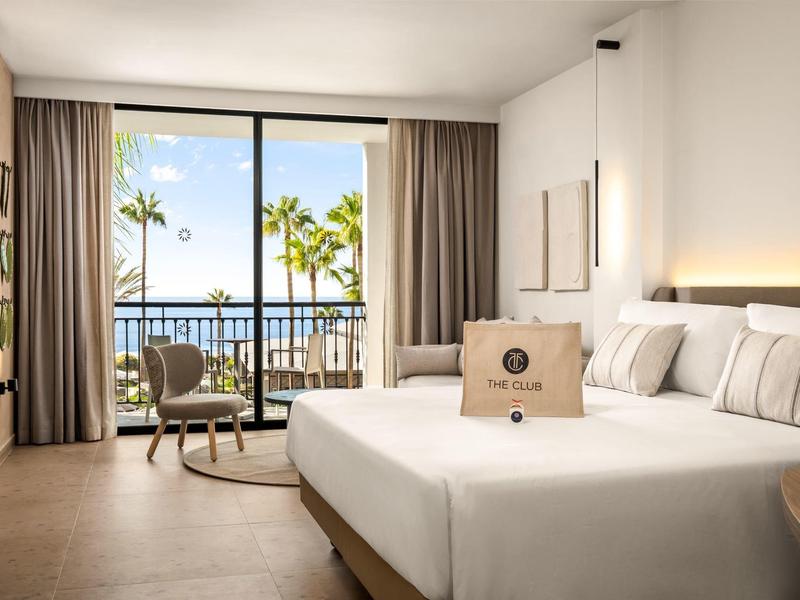 Jasny pokój hotelowy z podwójnym łóżkiem, balkonem i widokiem na morze, nowoczesne wnętrze