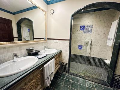 Łazienka z podwójną umywalką i prysznicem typu walk-in z przegrodą szklaną