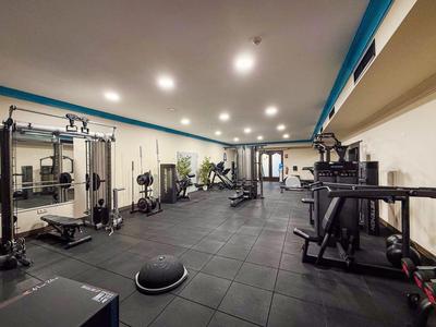 Modern gym with various exercise equipment and good lighting.