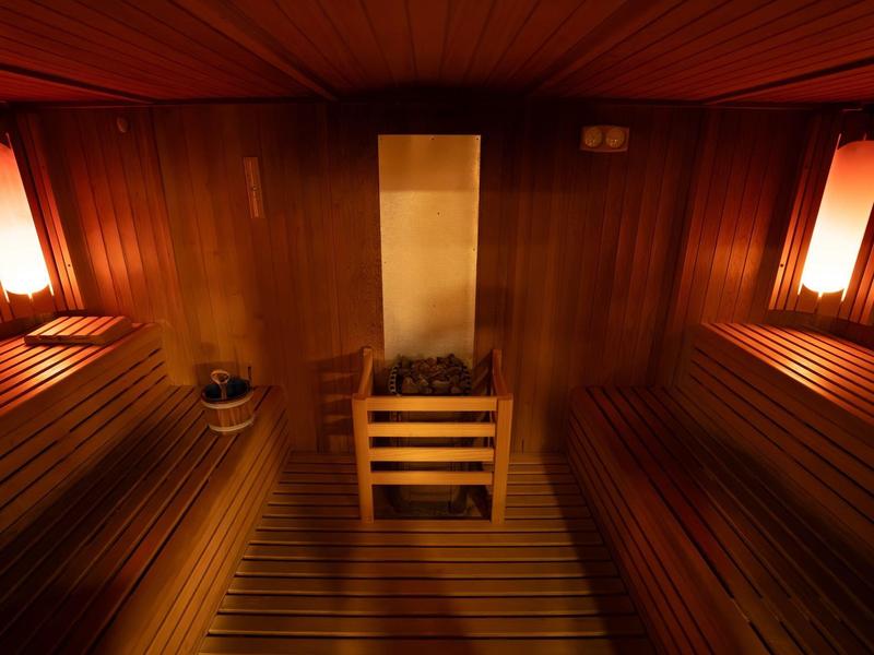 Przytulna sauna fińska z drewnianymi ławkami i ciepłym oświetleniem