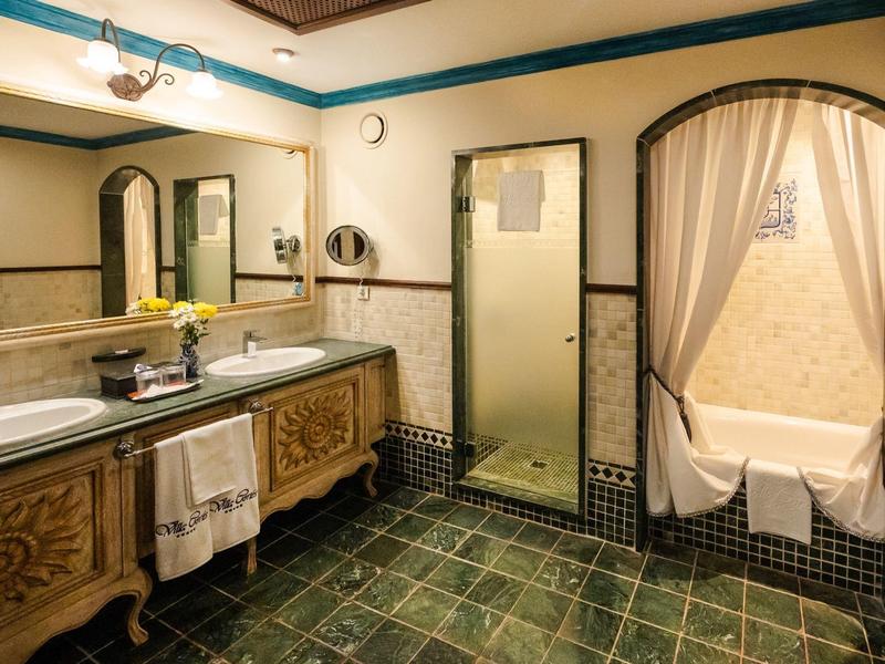 Jasna łazienka z podwójną umywalką, dużym lustrem i oddzielną wanną z zasłoną.