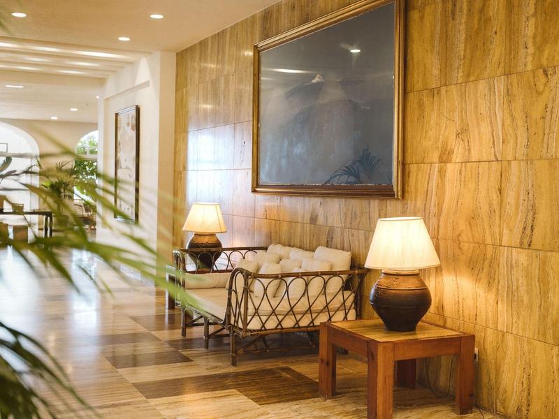 Accogliente zona salotto con pareti in legno, divano e lampade in un'area dell'hotel.