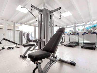 Modern gym with workout machines and treadmills in a bright, spacious room.