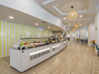 Moderne ontbijtbuffetruimte met lange balie en zitplaatsen in helder, uitnodigend ontwerp.