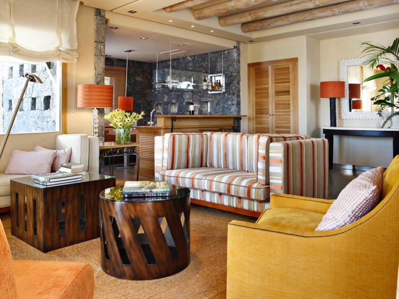 Pohodlný obývací pokoj s pruhovanou pohovkou, dřevěným nábytkem, teplým osvětlením a rostlinami.