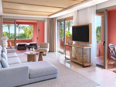 Modern ingerichte woonkamer met grote bank, glazen wanden en toegang tot een terras met zeezicht.