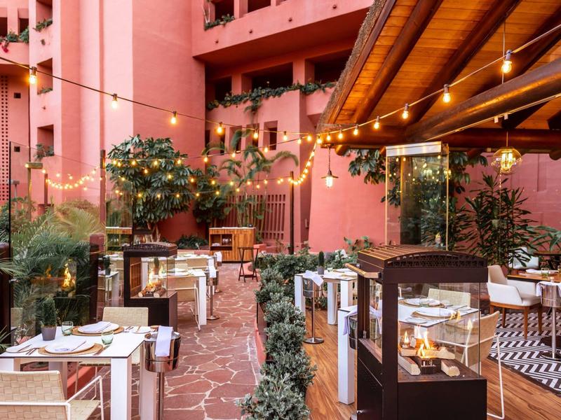 Gezellig terras van een restaurant met feestelijke lichtjes en mediterrane sfeer.