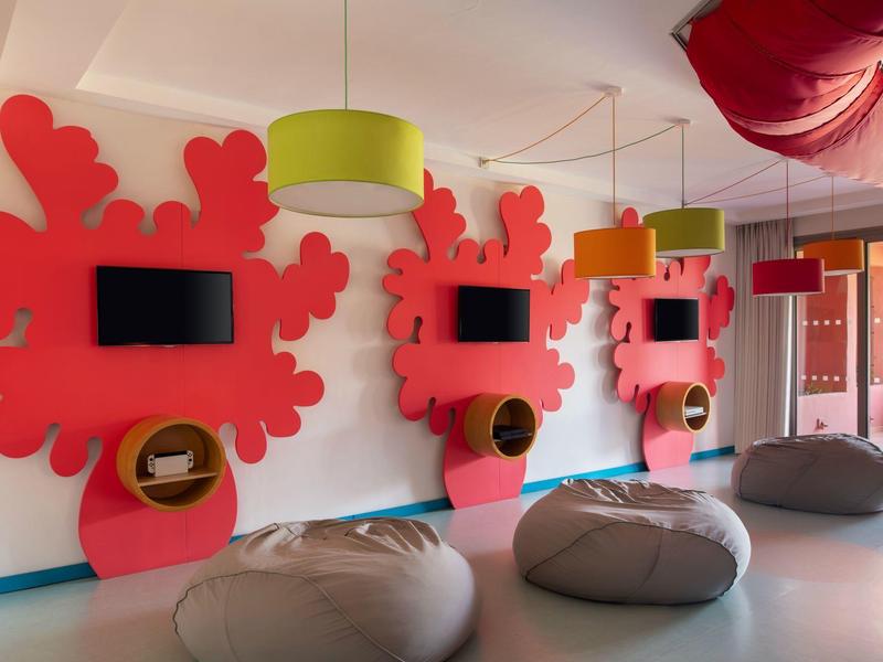 Moderne wellnessruimte met roze decoraties, zitzakken en spiegels aan de muur.