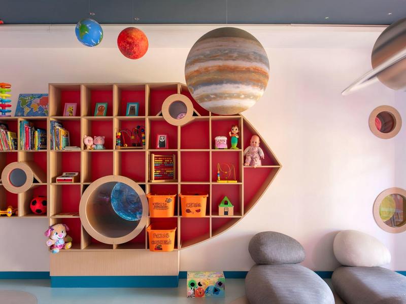 Kleurrijke kinderkamer met ruimte-thema en pijlvormige wandplanken.