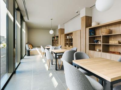 Modern dining room with wooden shelves, gray chairs, and large windows