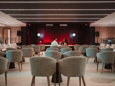 Modern conference room with rows of seats and stage in the background.