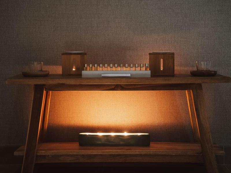 Warm lighting on a wooden shelf with two small lamps and an illuminated object below.