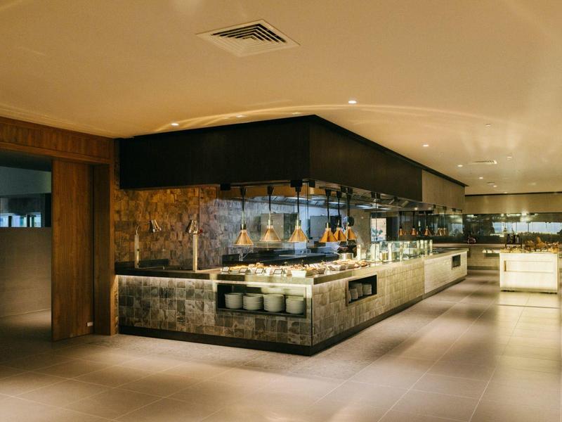 Modern hotel buffet area with stylish wood accents and warm lighting.