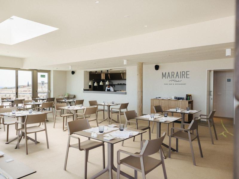 Bright, modern restaurant with tables, chairs, and large windows