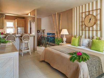 Camera d'hotel accogliente con letto, zona soggiorno e colori chiari naturali.