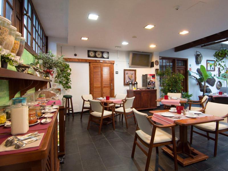 Salle de petit-déjeuner accueillante avec meubles en bois et tables dressées dans un hôtel.