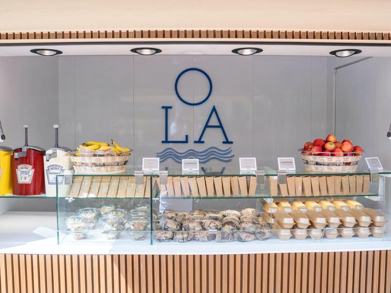 Frühstücksbar mit Muffins, Eiern, Obst und Getränken in einem Hotel