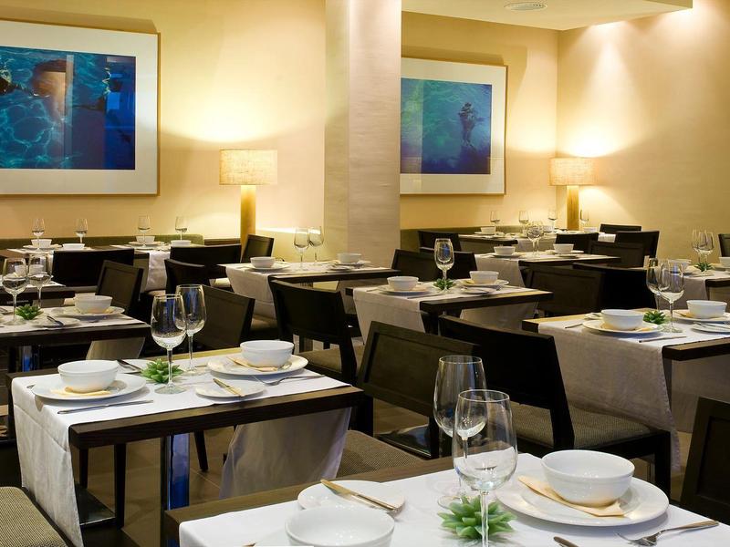 Restaurant élégant avec tables dressées et art moderne aux murs.