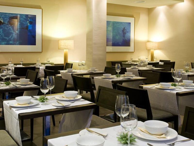 Restaurant élégant avec des tables dressées, de la verrerie et un éclairage chaleureux.