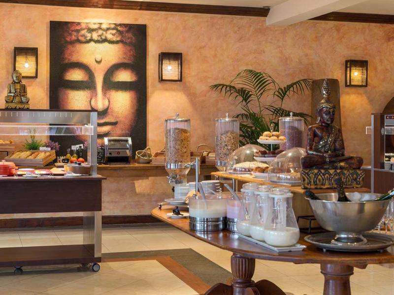 Strefa bufetu z różnymi potrawami i dekoracyjną twarzą Buddy w tle