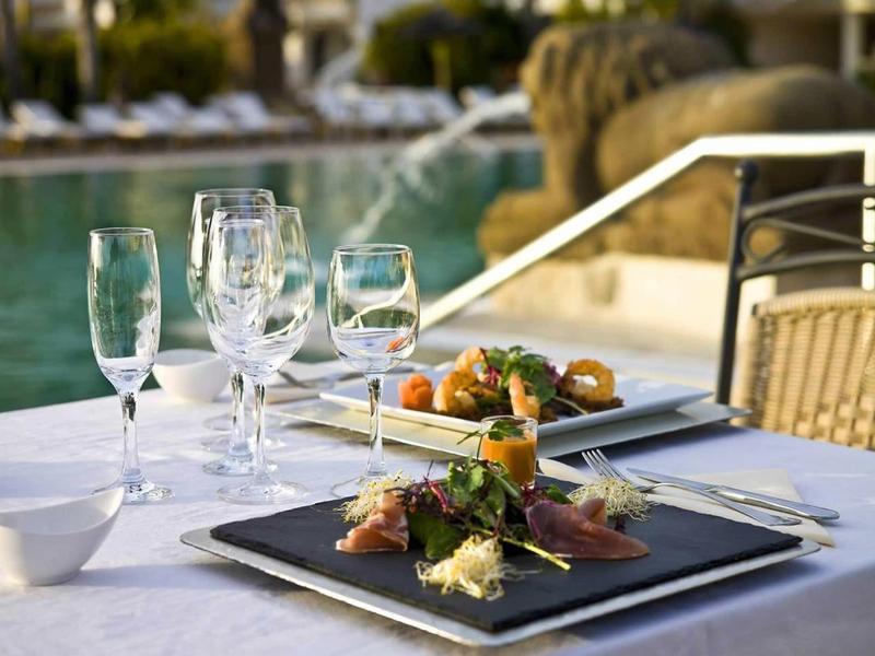Elegancka zastawa stołowa z kieliszkami do wina obok basenu hotelowego.