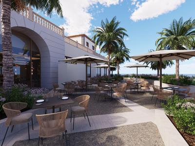 Outdoor hotel terrace with chairs and umbrellas under palm trees on a clear sky day.