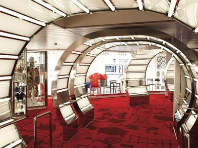 Eleganter Hotellobby mit roten Teppichen, spiegelnden Bögen und moderner Beleuchtung.