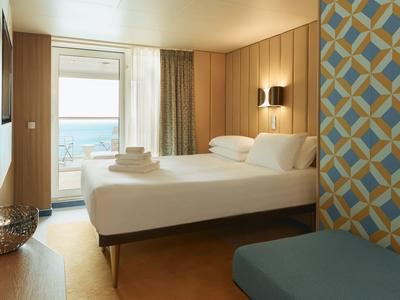 Modernes Hotelzimmer mit Doppelbett, Balkon und Meerblick.