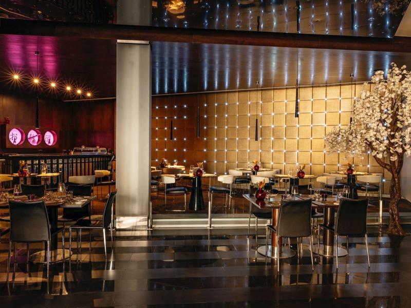 Modern, elegant restaurant met stijlvolle verlichting en decoratieve elementen.