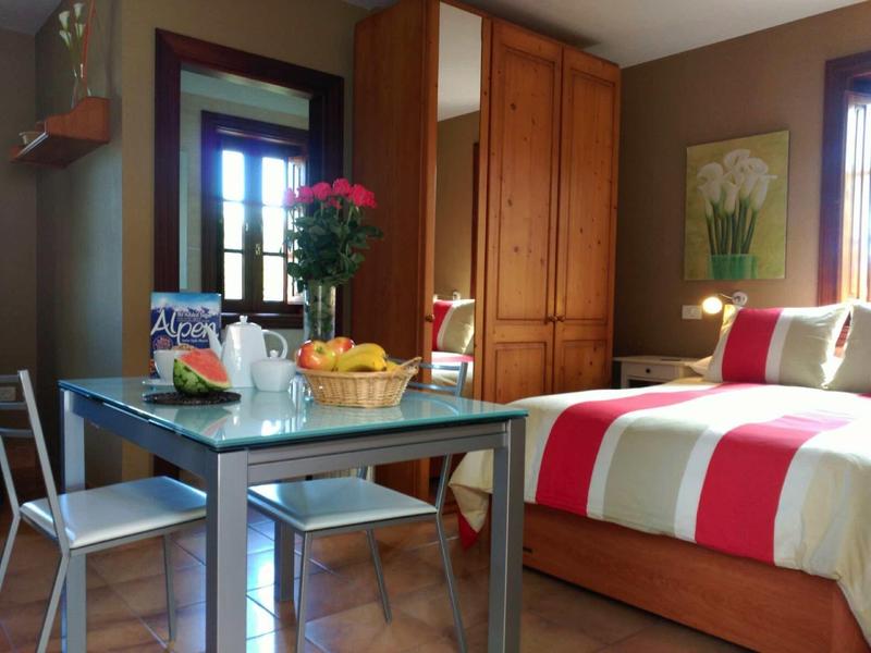 Chambre d'hôtel confortable avec lit double, table, chaises et fenêtre avec vue extérieure.